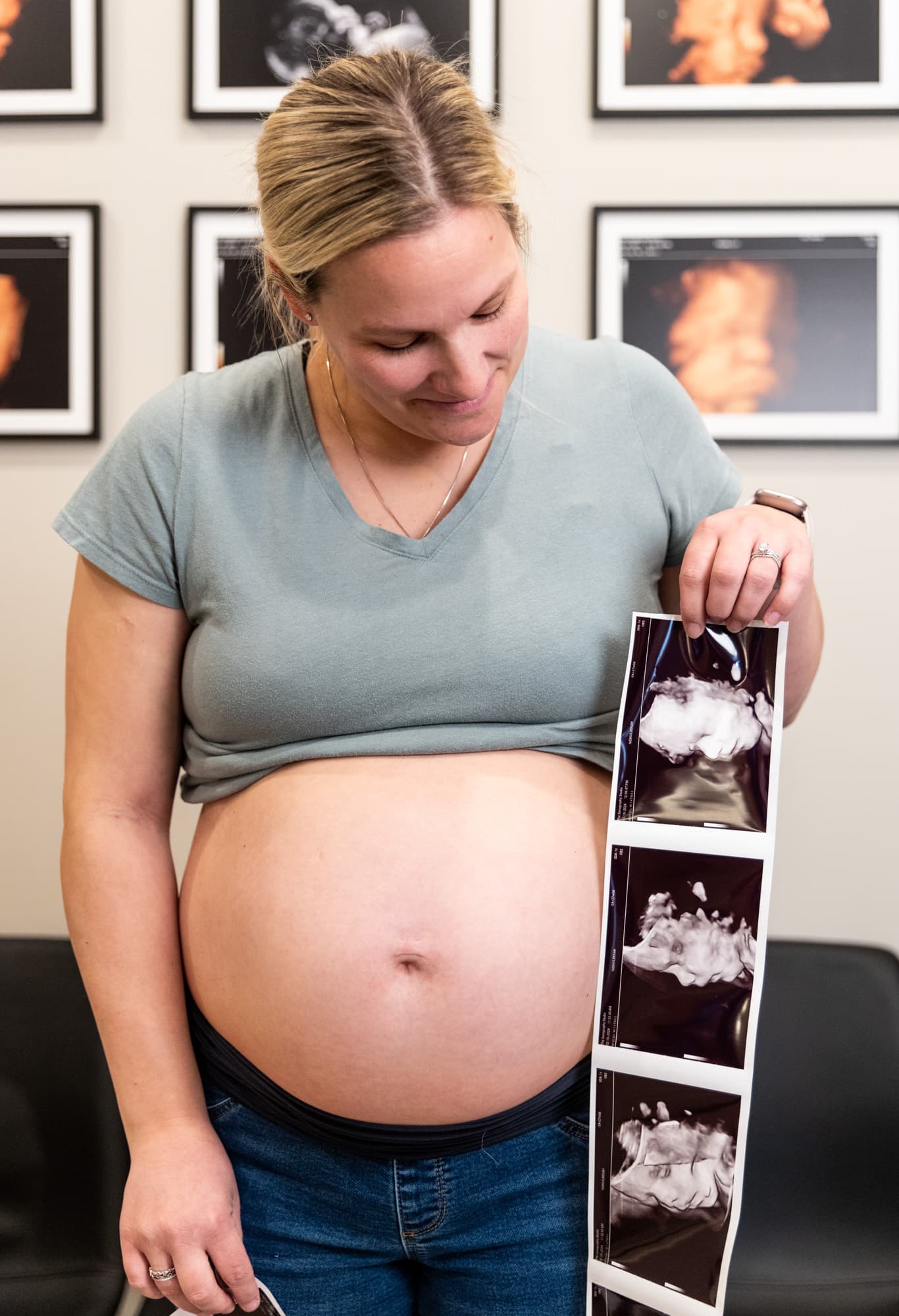 An expecting mother holding her printed ultrasound photos at The Sonography Studio