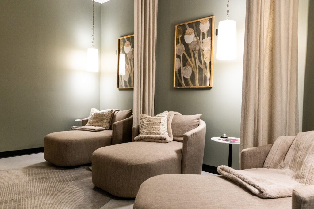 A sitting room with a few large chairs and neutral, calming decor at a women's clinc.