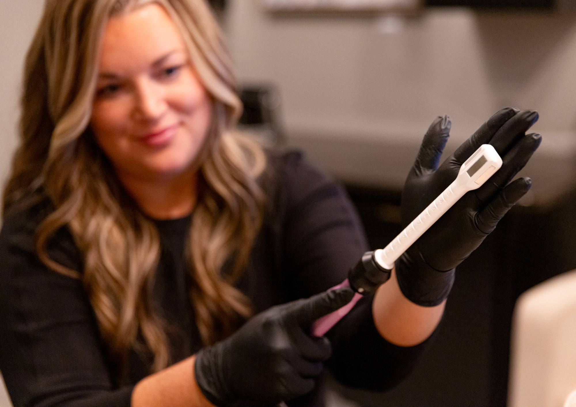 At The Sonography Studio, a women's clinic in Sioux City, a woman holds up a device for vaginal rejuvenation.